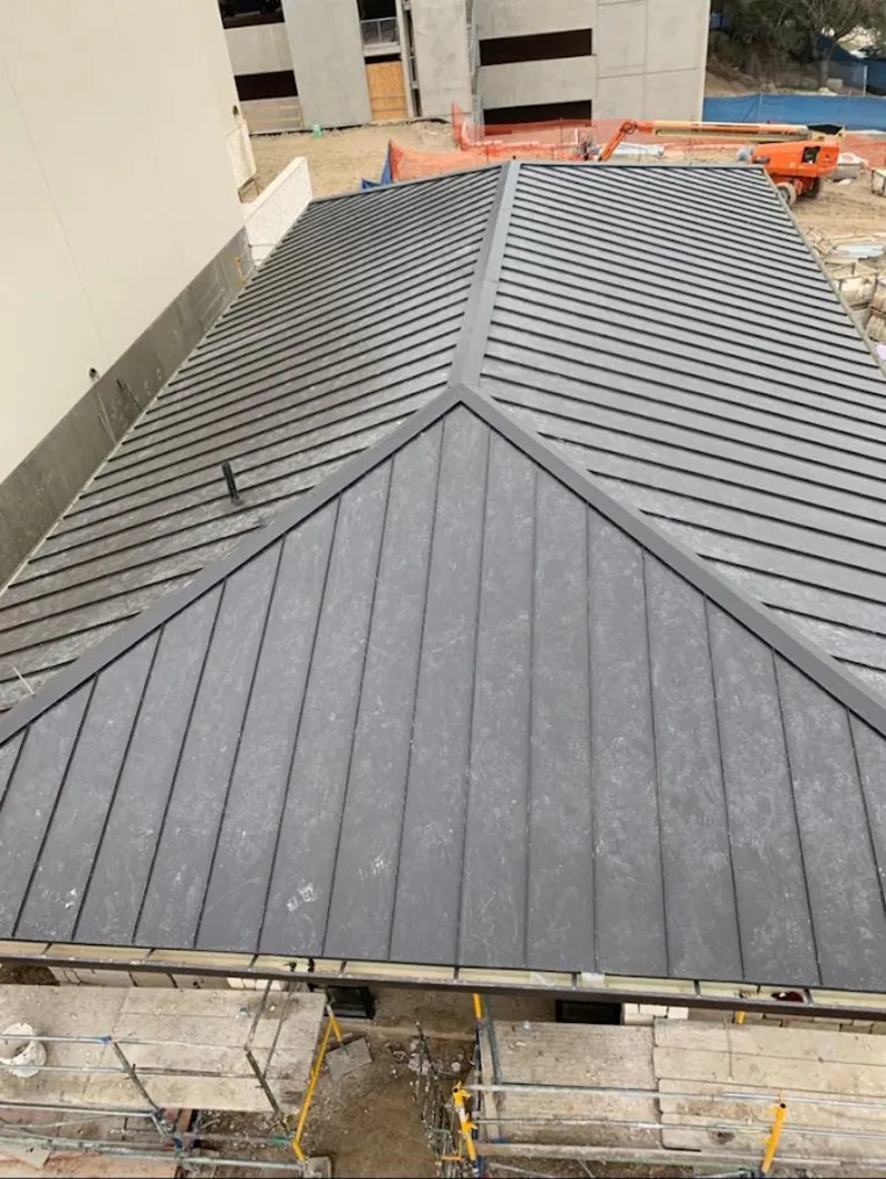 Commercial metal roof construction with crane equipment in West Springfield Town